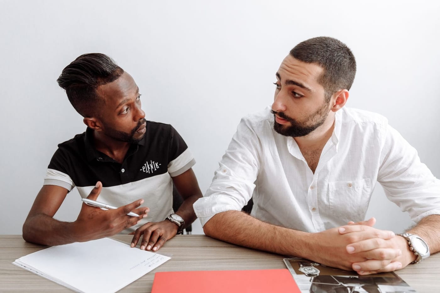 Two colleagues at a table working through a disagreement.